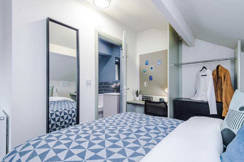 Bright, neatly styled double bedroom with a pat...