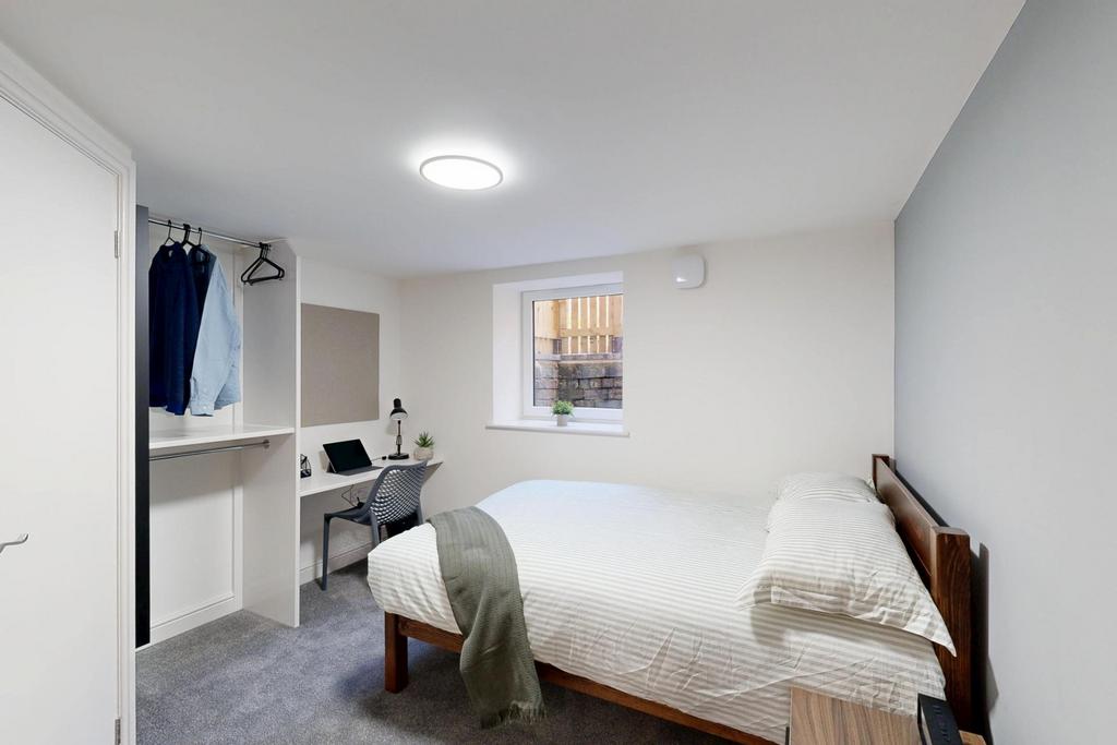 A bright and tidy bedroom featuring a comfortab...