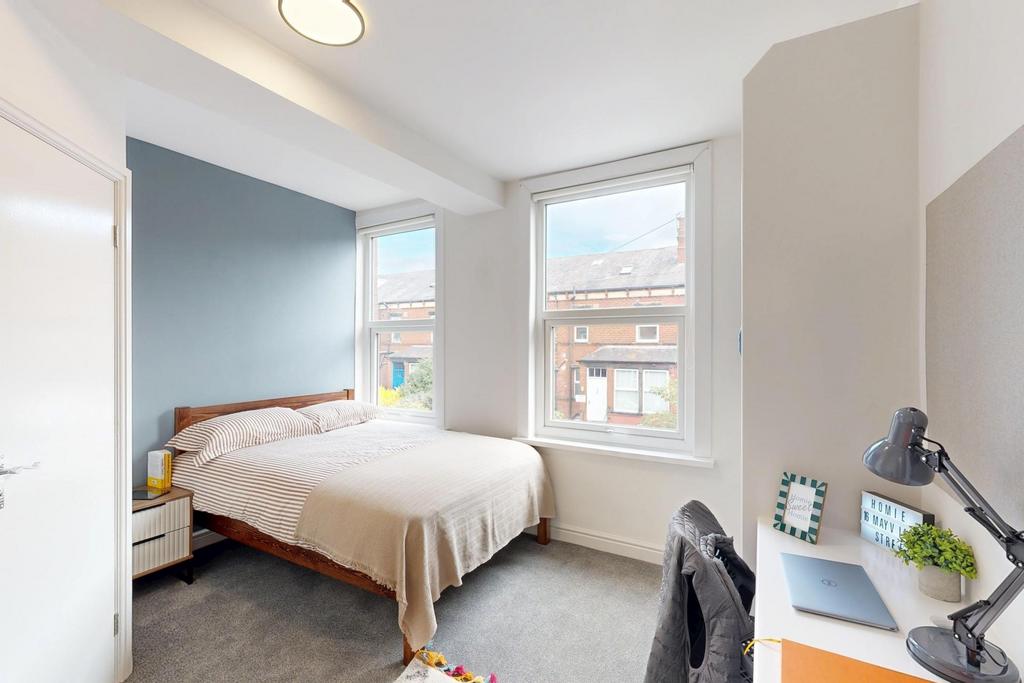 A bright and inviting bedroom featuring a comfo...