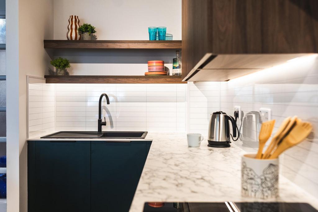 Modern kitchenette with sleek dark cabinetry, m...