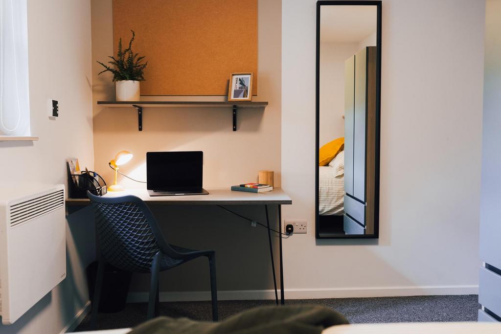 Bright, tidy bedroom corner with a neat study a...