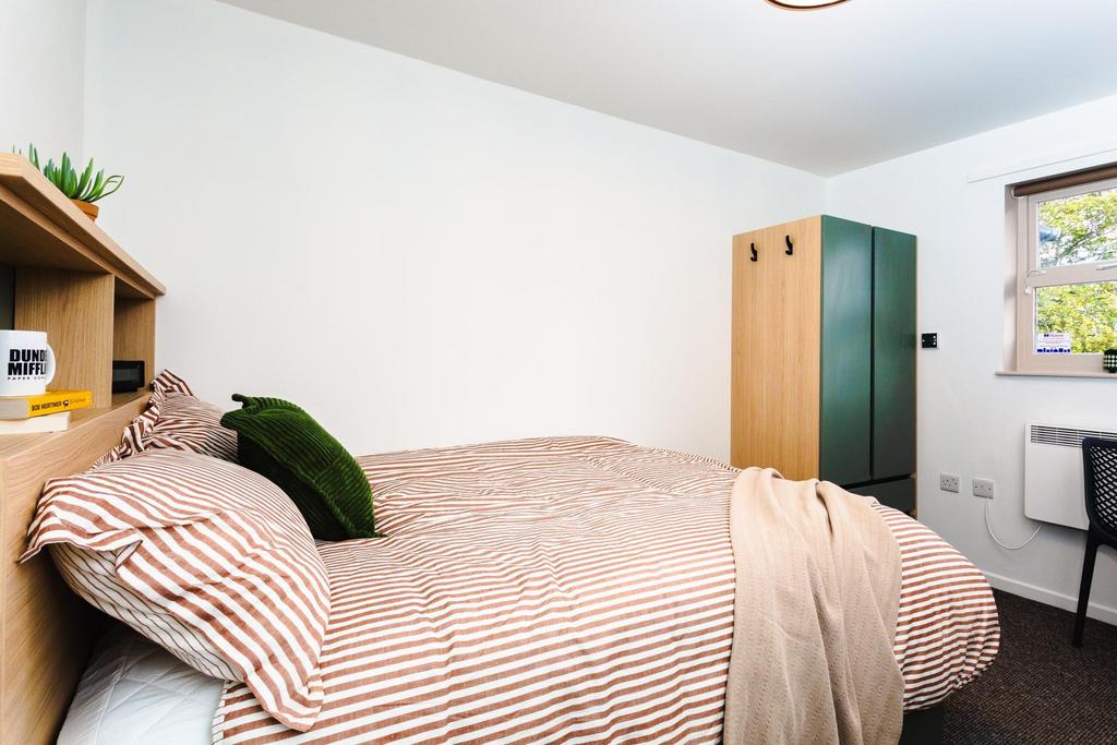 Bright, neatly presented bedroom with a comfort...