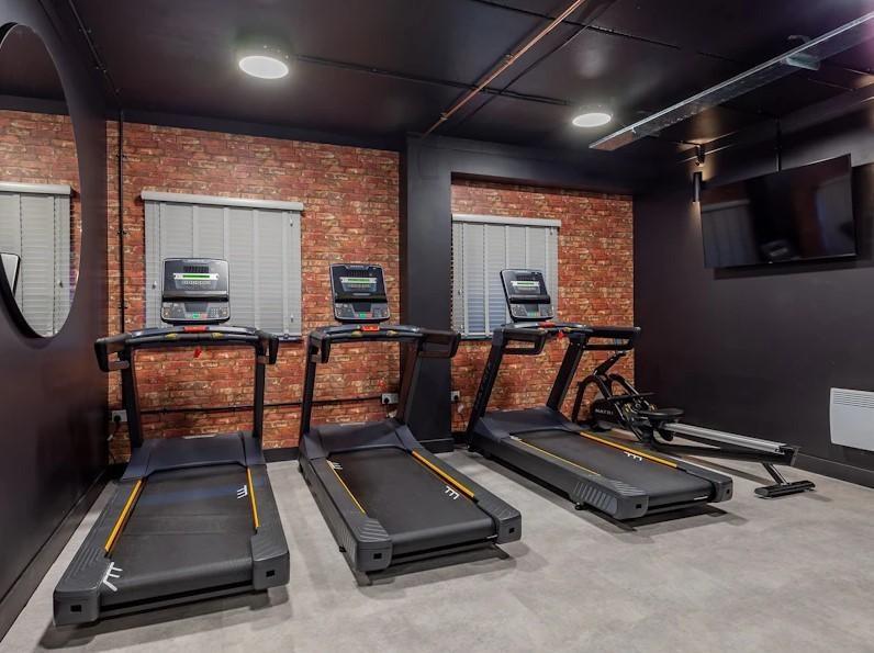 A well-equipped gym area featuring multiple exe...