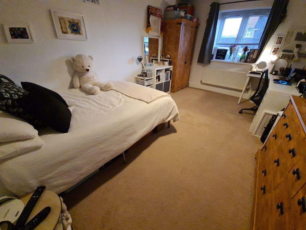 A cozy bedroom featuring a neatly made bed with...