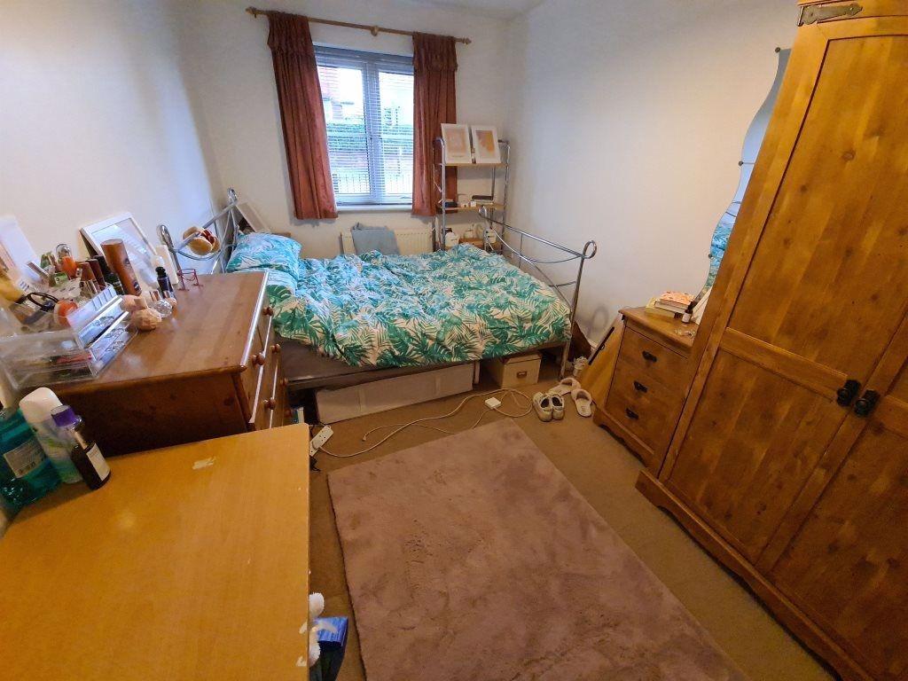 A spacious and cozy bedroom featuring a large b...