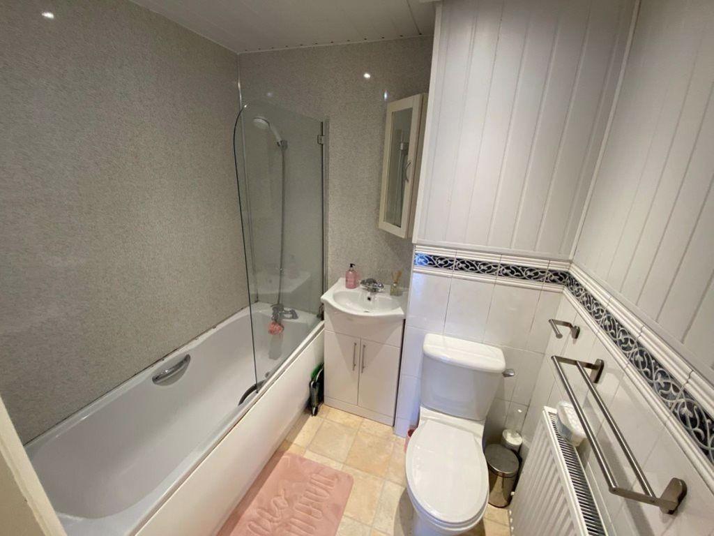 A clean and modern bathroom featuring a bathtub...