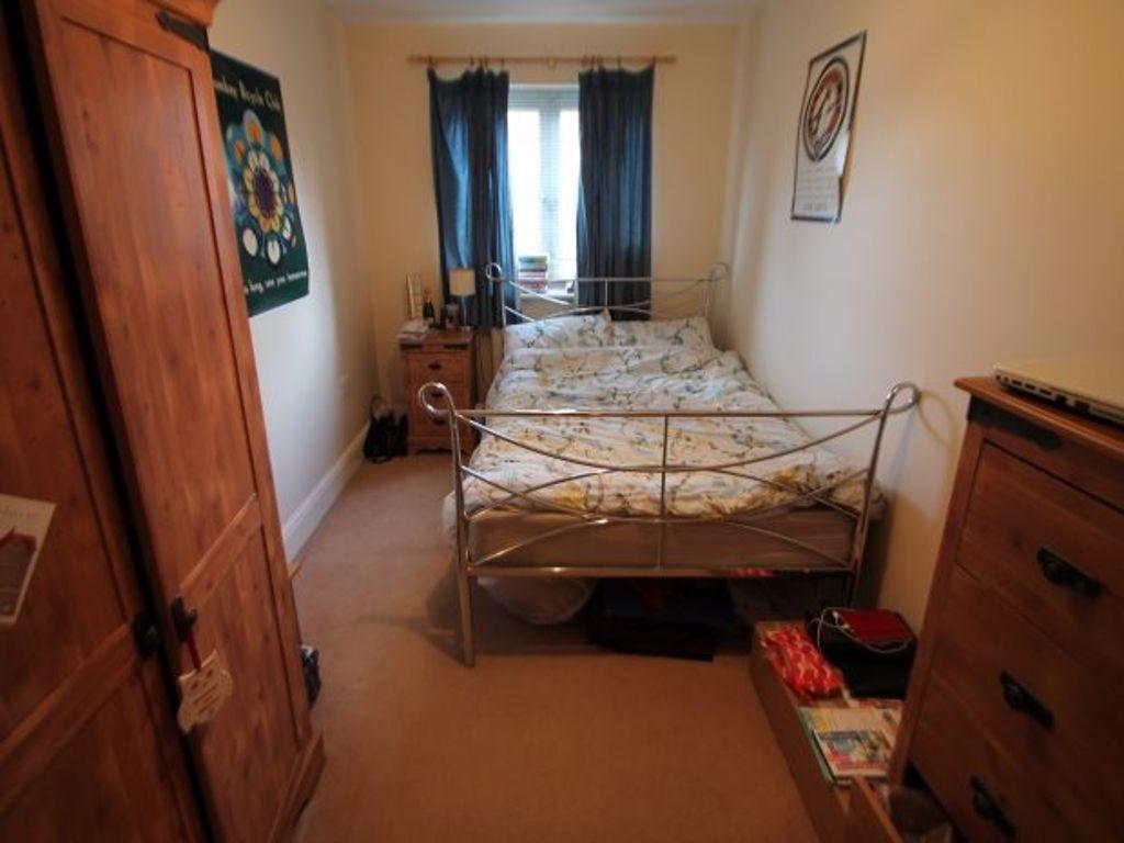 A cozy master bedroom featuring a metal bed fra...