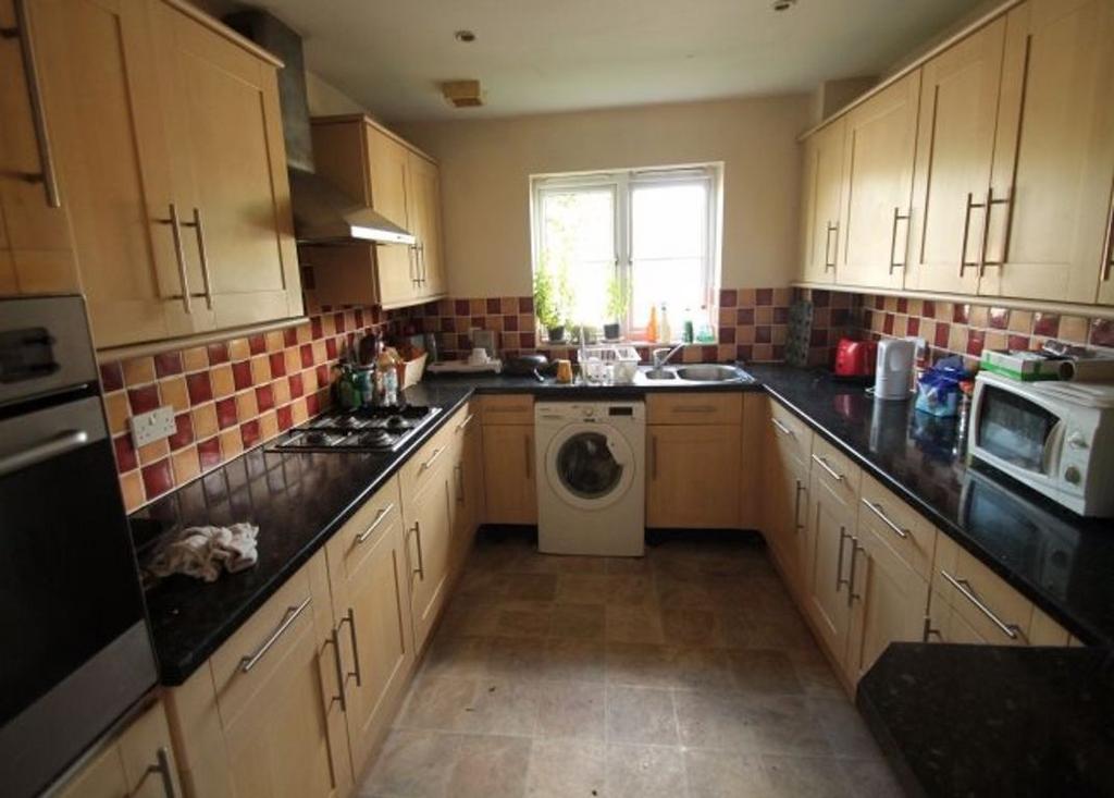 A well-lit kitchen area with ample counter spac...