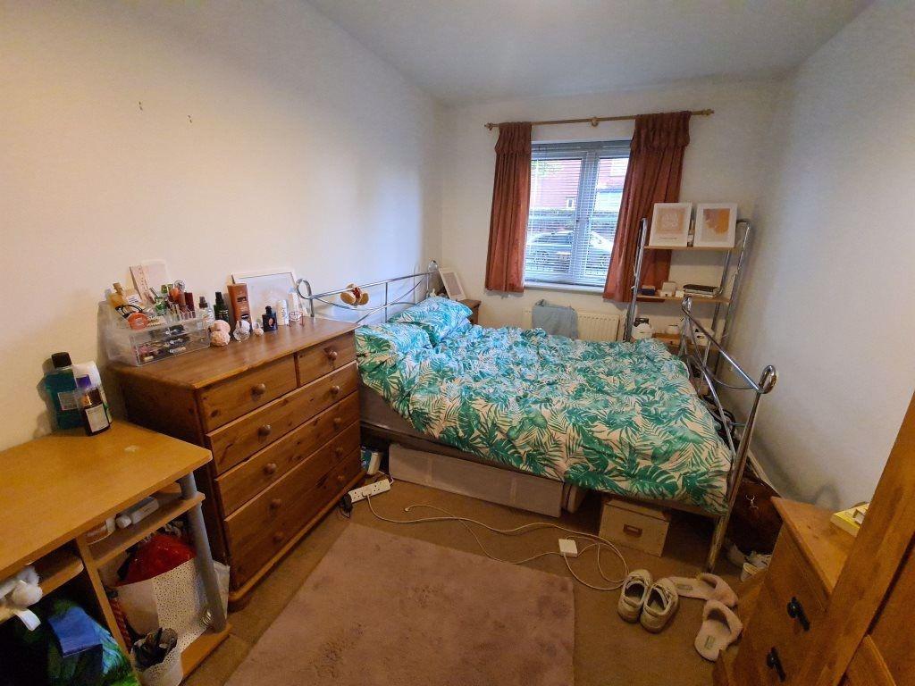 A modest bedroom featuring a double bed with so...