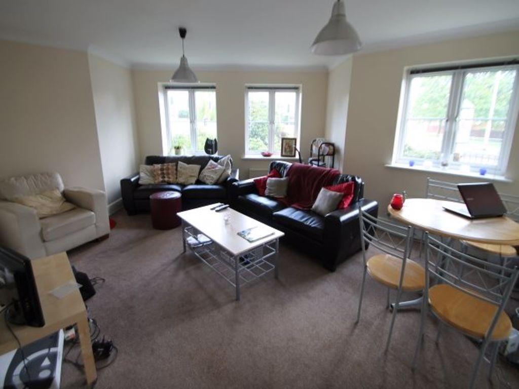 A spacious and well-lit living room featuring a...