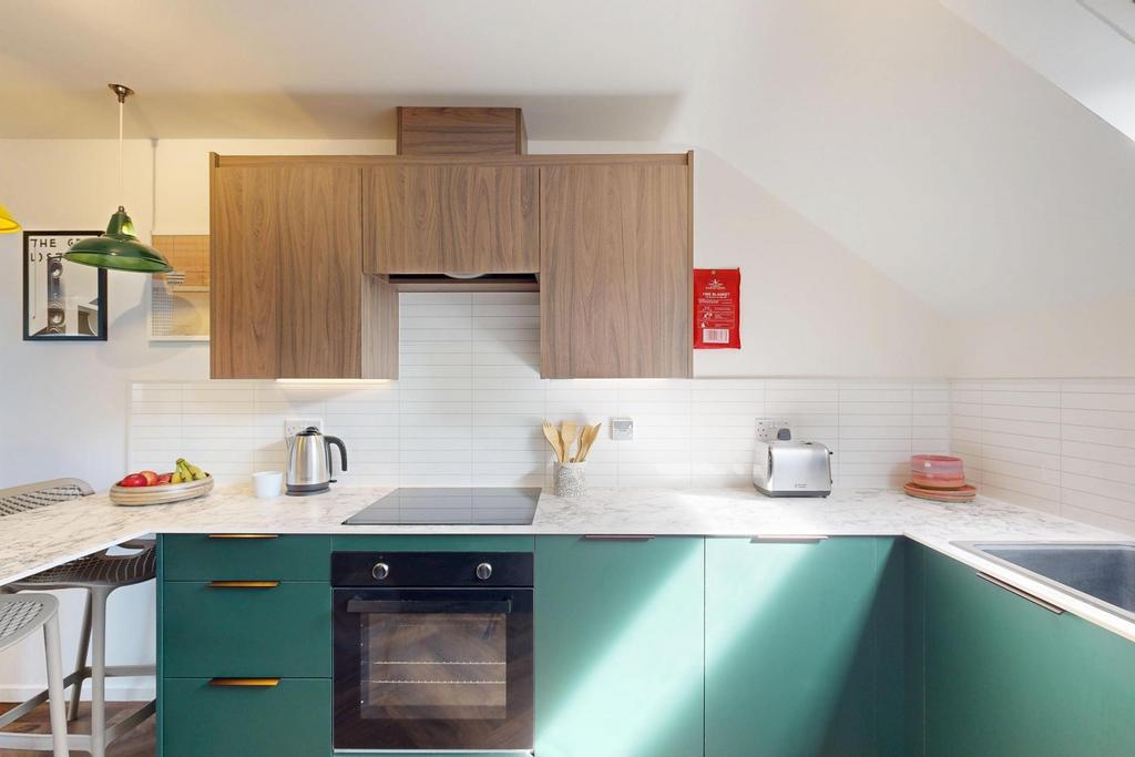 Modern kitchen with green lower cabinets, wood-...
