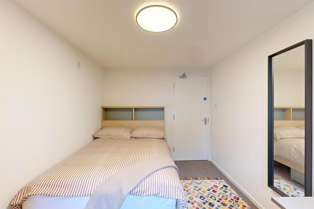 A bright and tidy bedroom featuring a double be...
