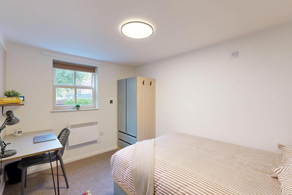 A bright and tidy single bedroom featuring a co...