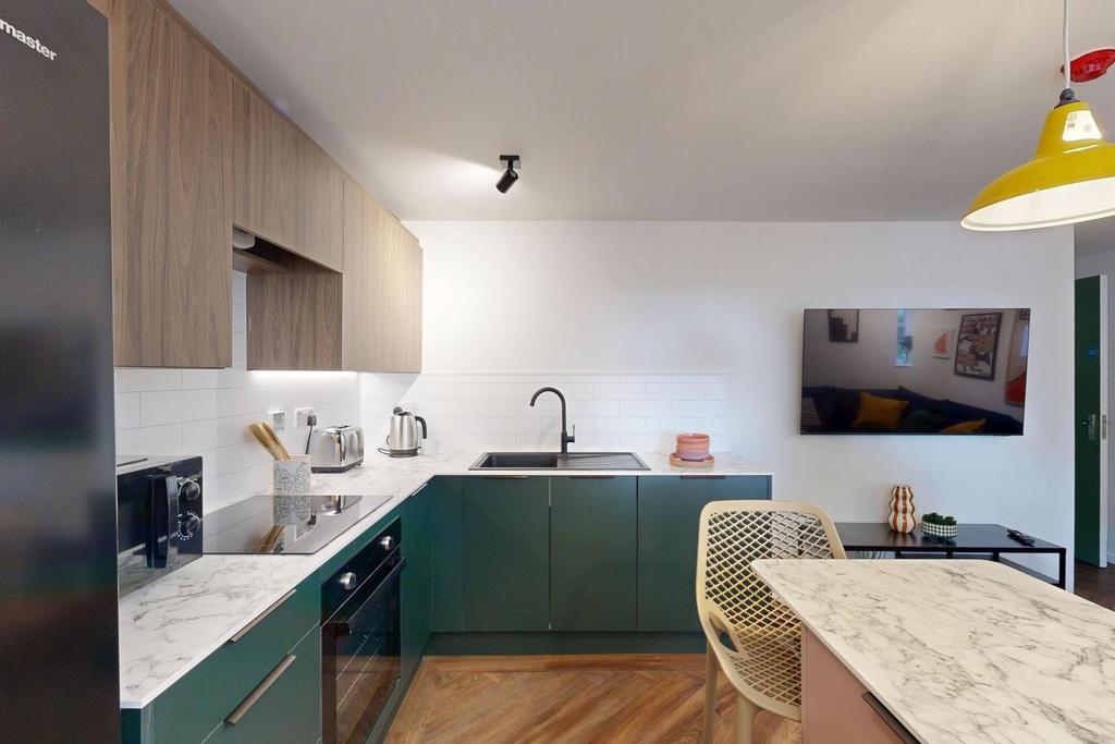 A modern, well-lit kitchen featuring sleek gree...