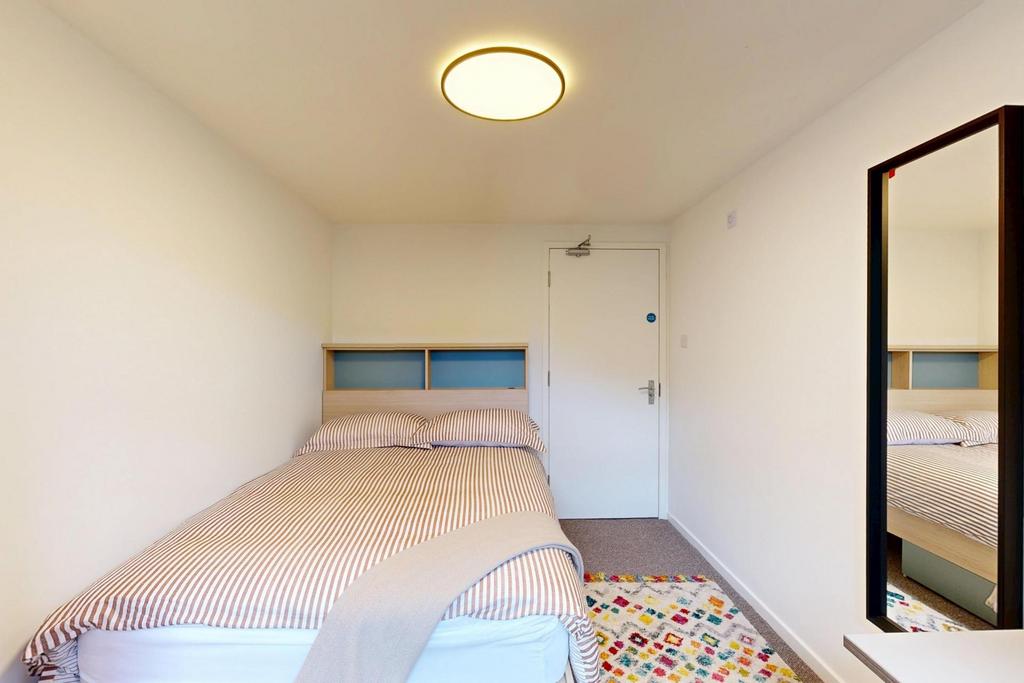 A bright and tidy bedroom featuring a comfortab...