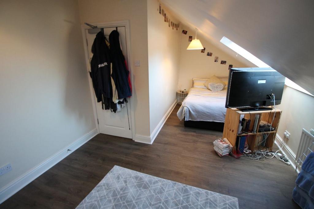 A cozy bedroom featuring a neatly made bed, a s...