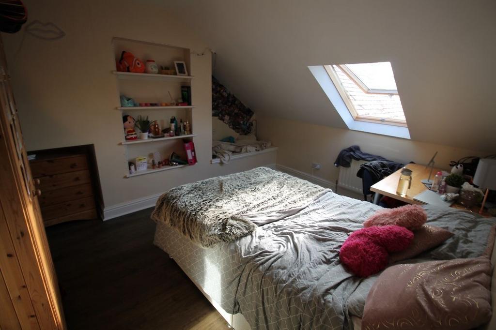 A cozy bedroom with a bed, soft cushions, and a...