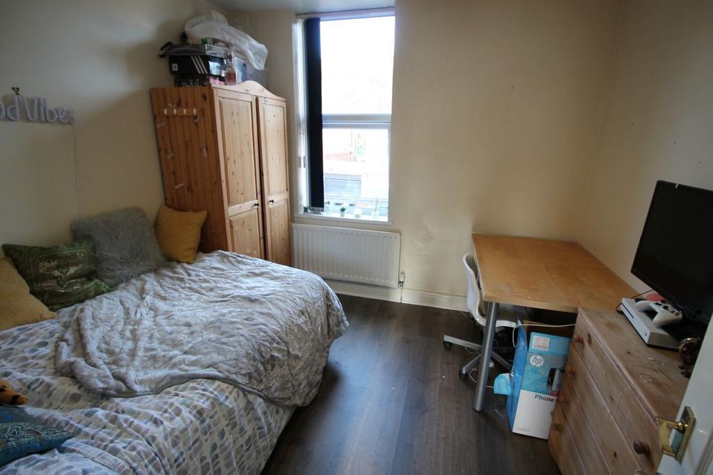 A cozy bedroom featuring a double bed, a wooden...