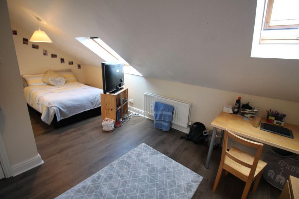 A bright, well-maintained bedroom with a comfor...