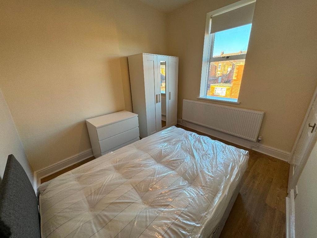 A cozy student bedroom featuring a comfortable ...