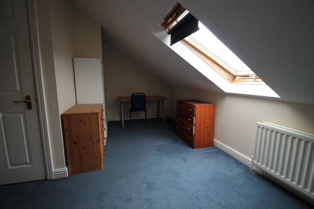 A cozy bedroom with an attractive skylight wind...