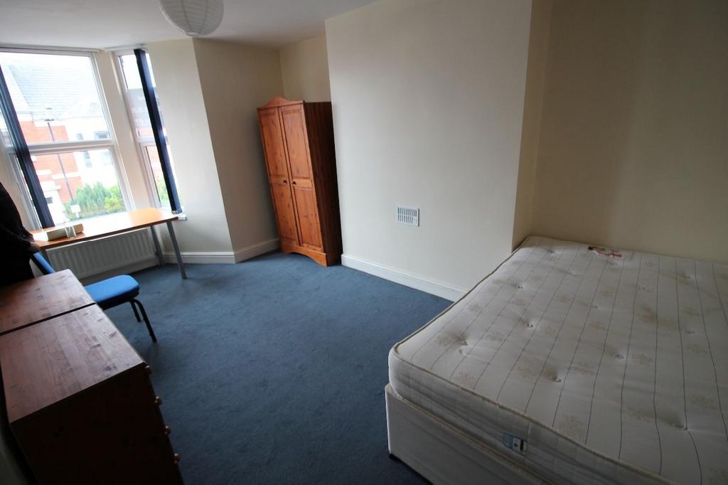 A modest bedroom featuring a large window that ...