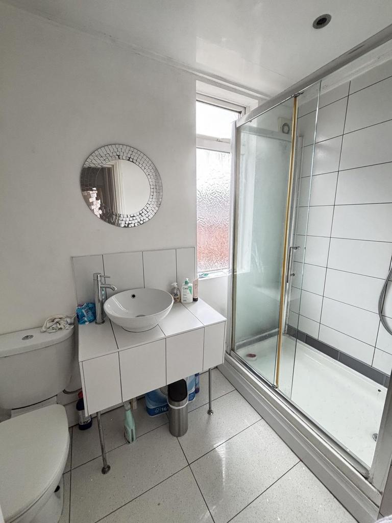 Bright, modern bathroom with a glass-enclosed s...