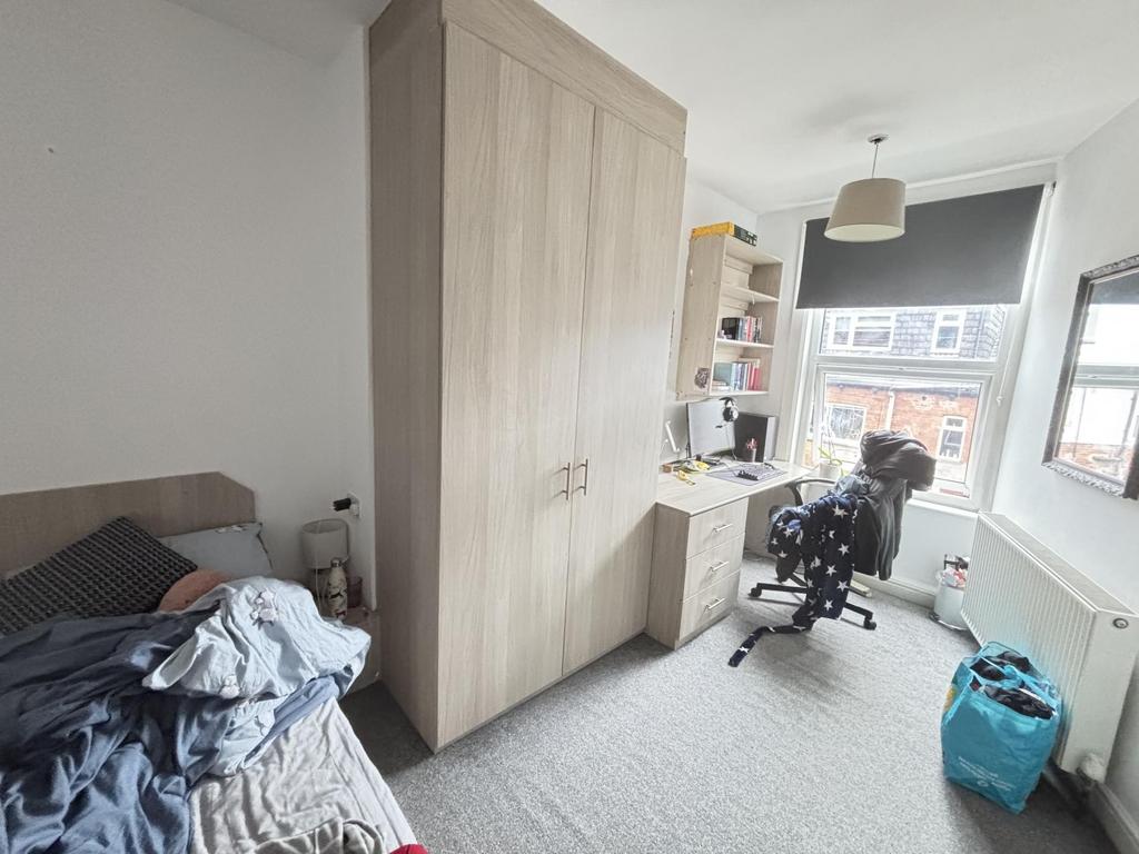 Bright single bedroom with a window-facing stud...