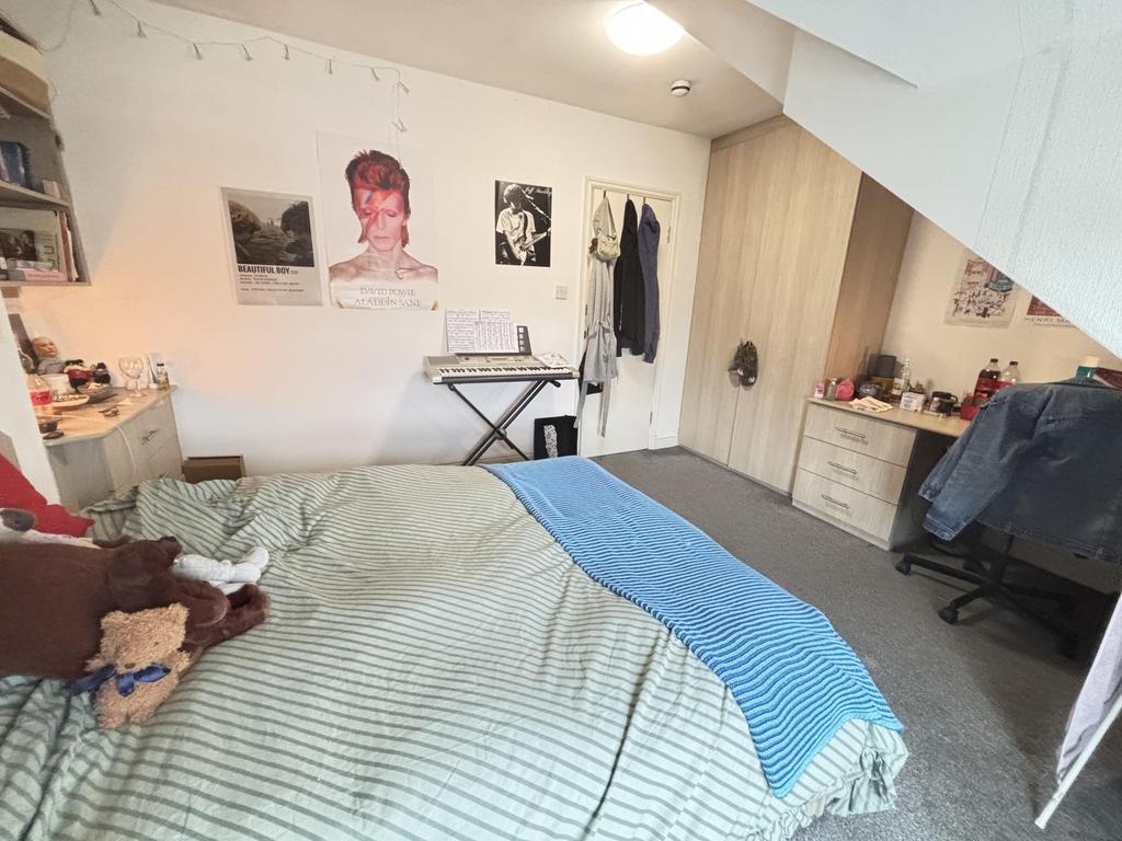Cozy double bedroom with a made bed, bedside sh...