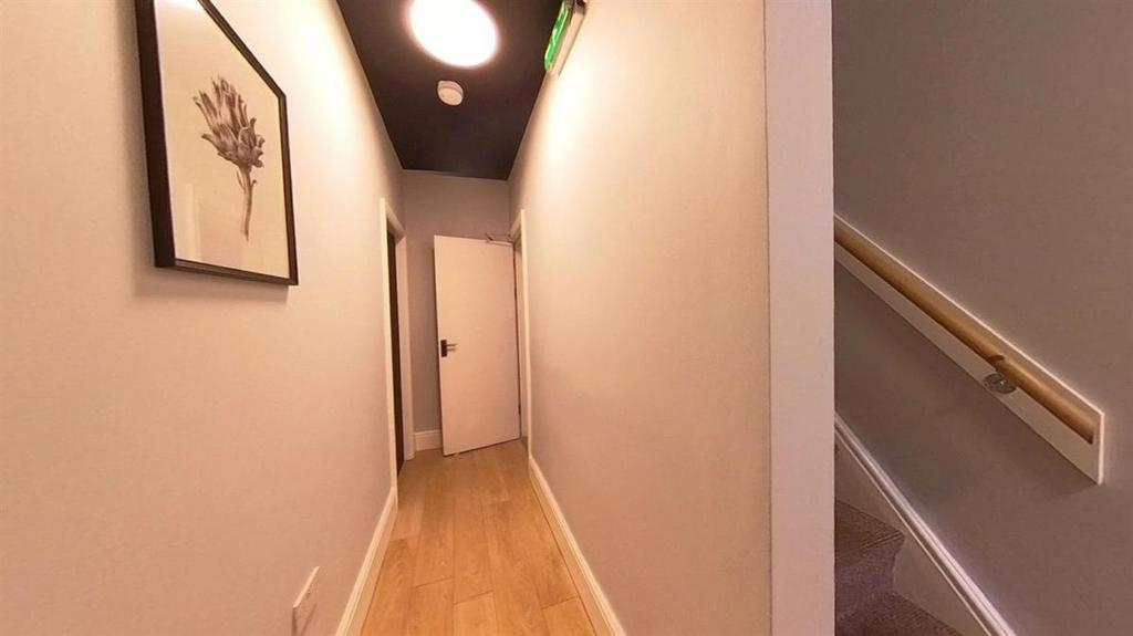 A well-maintained corridor with light-colored w...