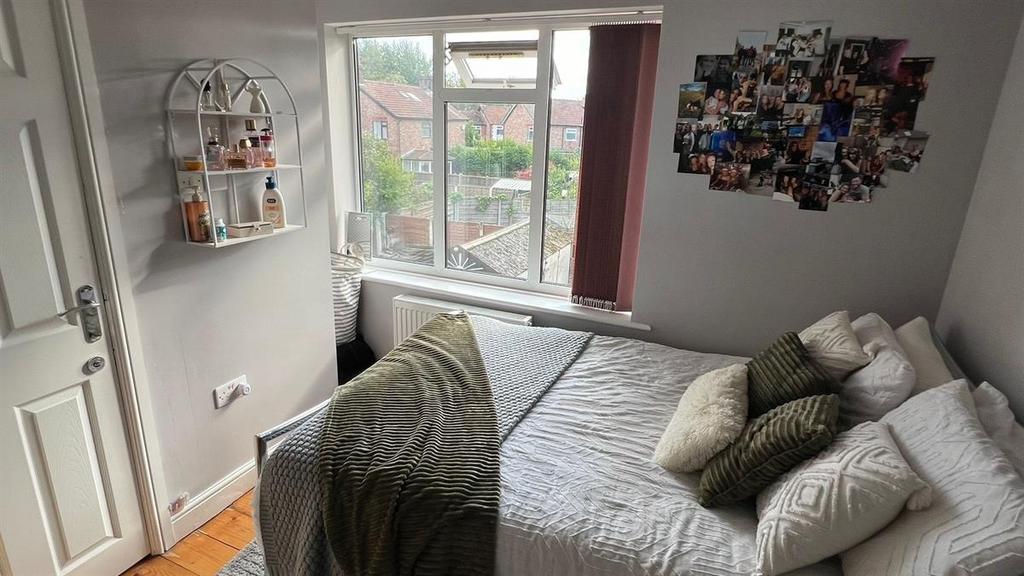 A well-lit, inviting double bedroom featuring a...