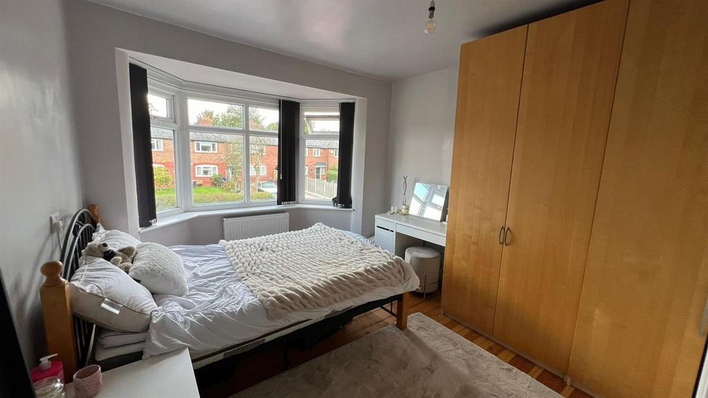 A cozy single bedroom featuring a bed, a wardro...