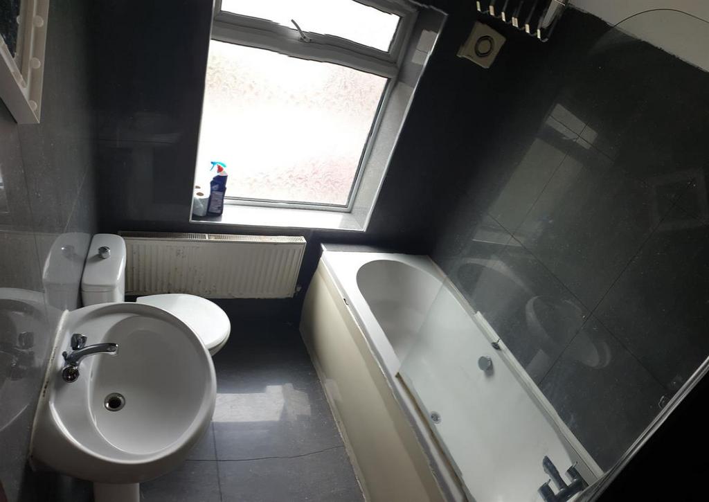 A spacious bathroom featuring a large bathtub a...