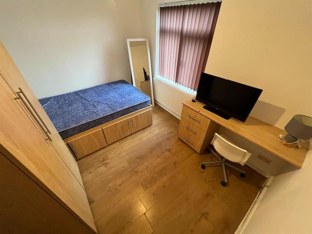 A cozy student bedroom featuring a single bed, ...
