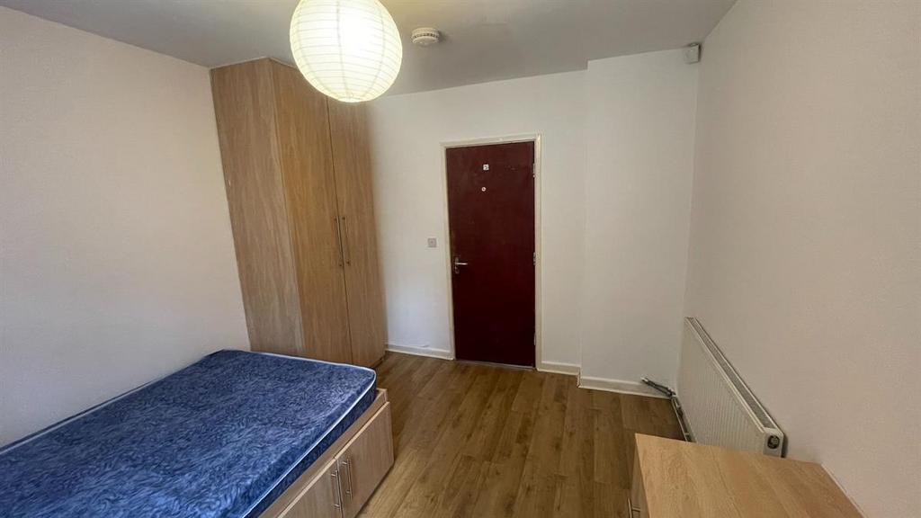 A clean and simple bedroom featuring a single b...