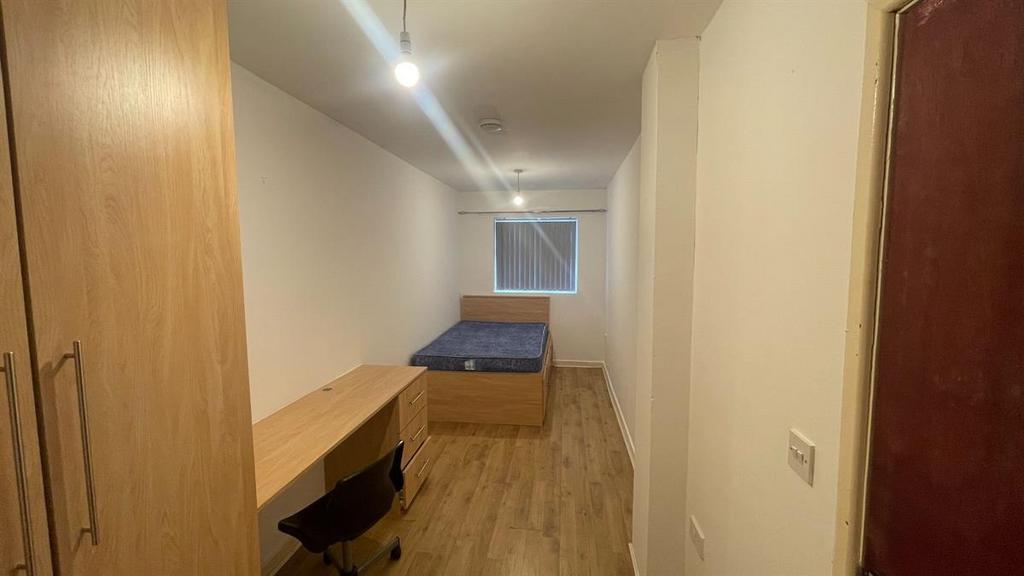 A compact but well-maintained bedroom with a si...