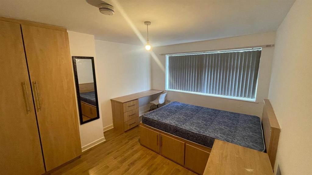 A well-kept bedroom featuring a double bed, a w...