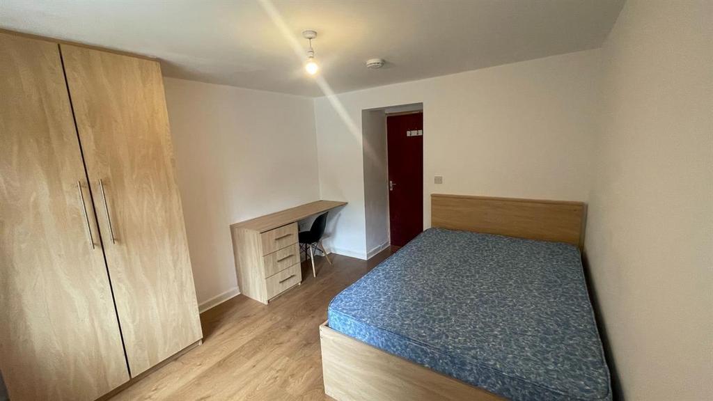 A cozy bedroom featuring a double bed, fitted w...