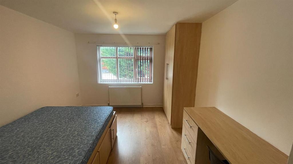 A bright and tidy bedroom with a large window p...
