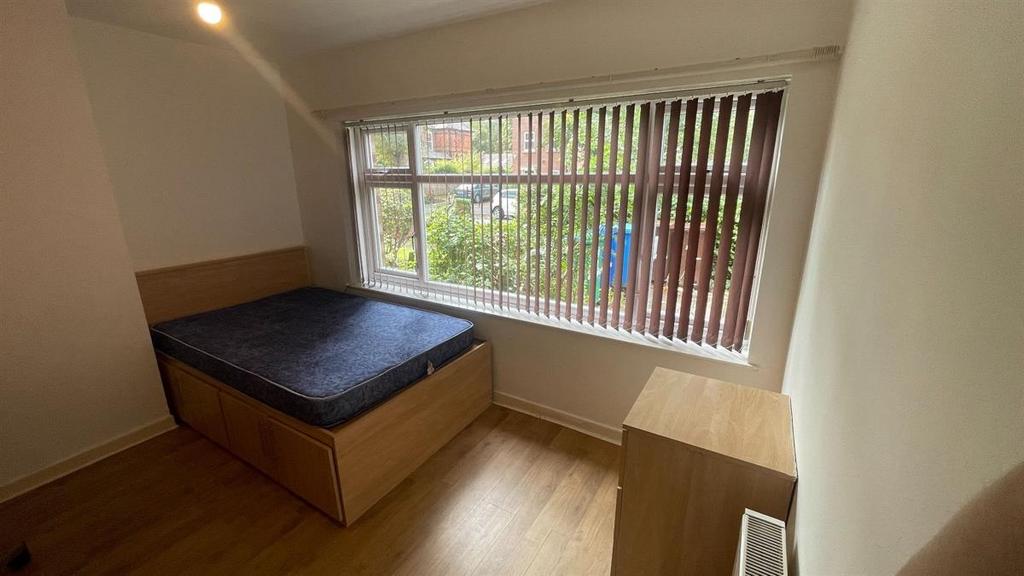 A bright double bedroom featuring a comfortable...