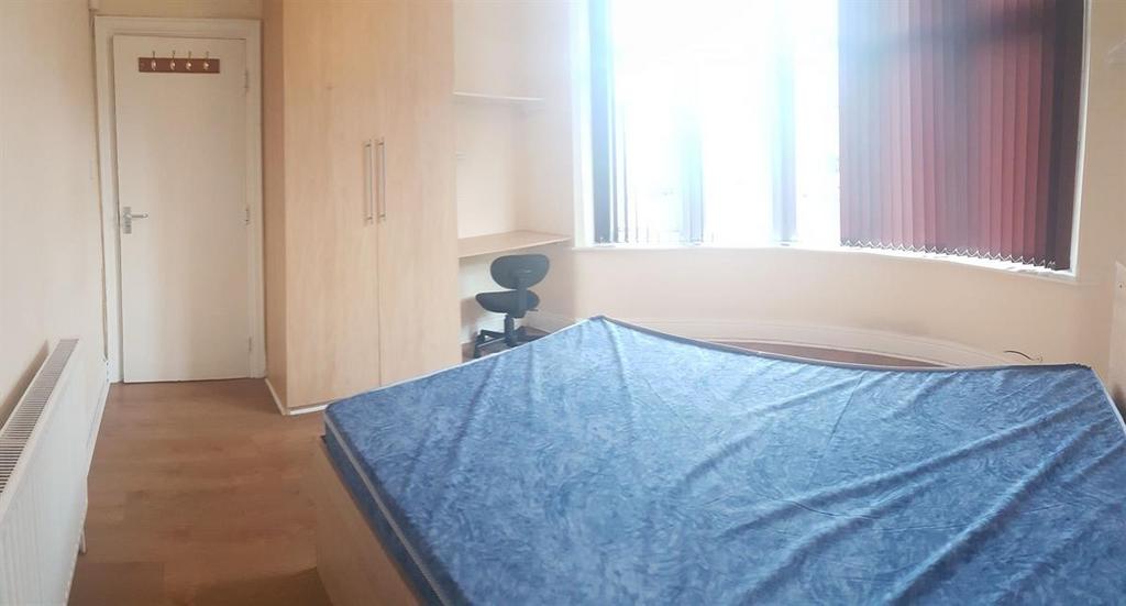 A well-lit bedroom featuring a bed with a blue ...