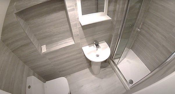 A clean and modern bathroom featuring a shower,...