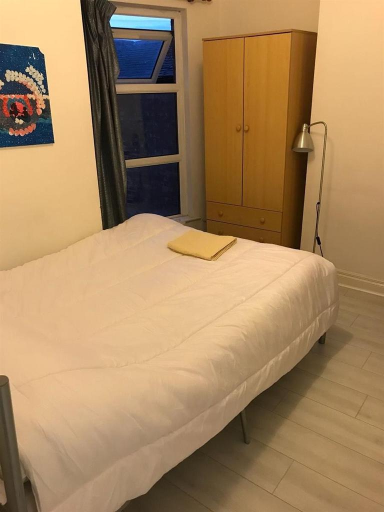 A comfortable single bedroom with a tidy bed, a...