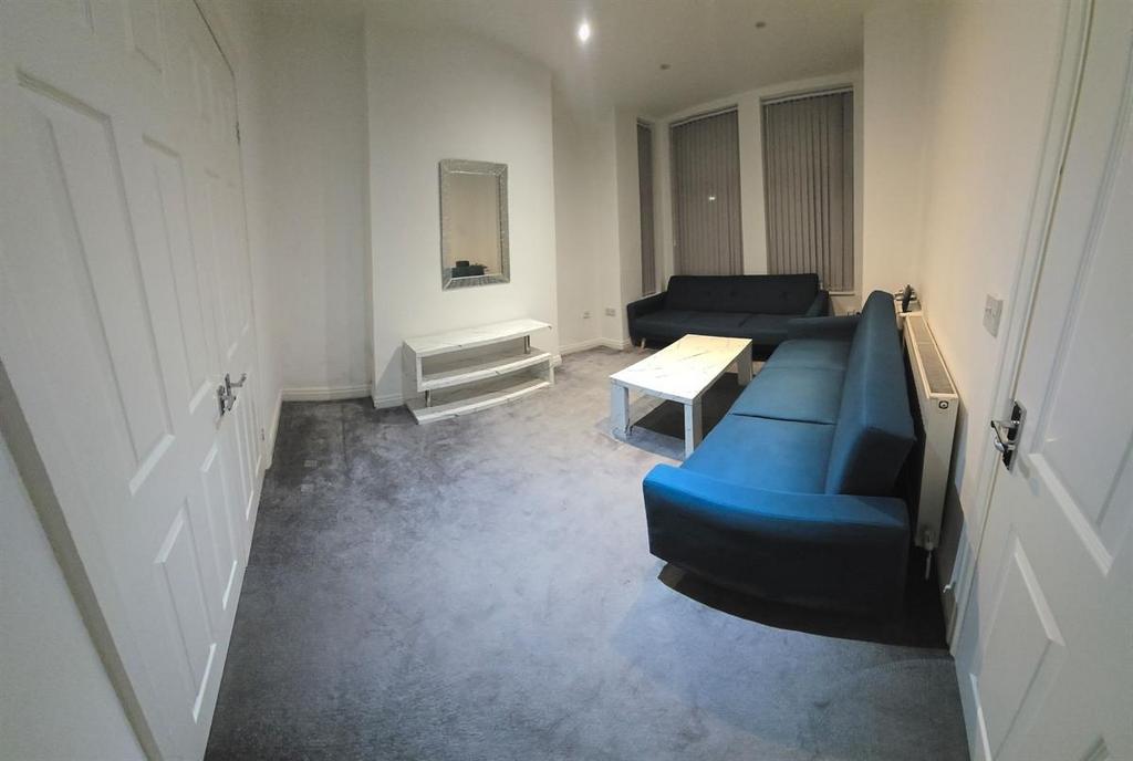 A modern living room with a blue sofa, white co...