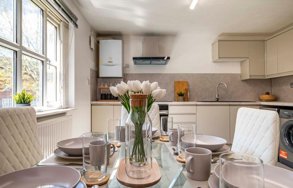 A bright and modern dining area with a glass ta...