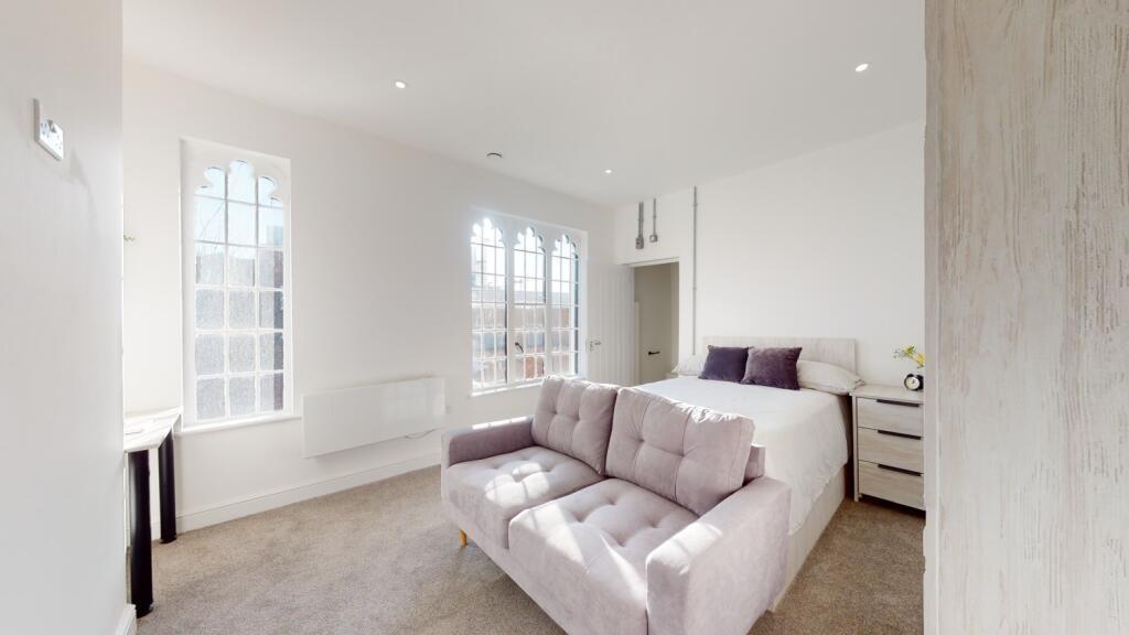 Bright and spacious living room featuring large...