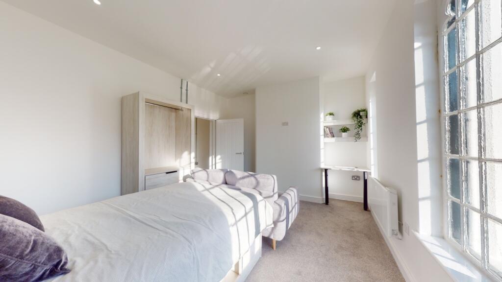 Bright and airy bedroom featuring plenty of nat...