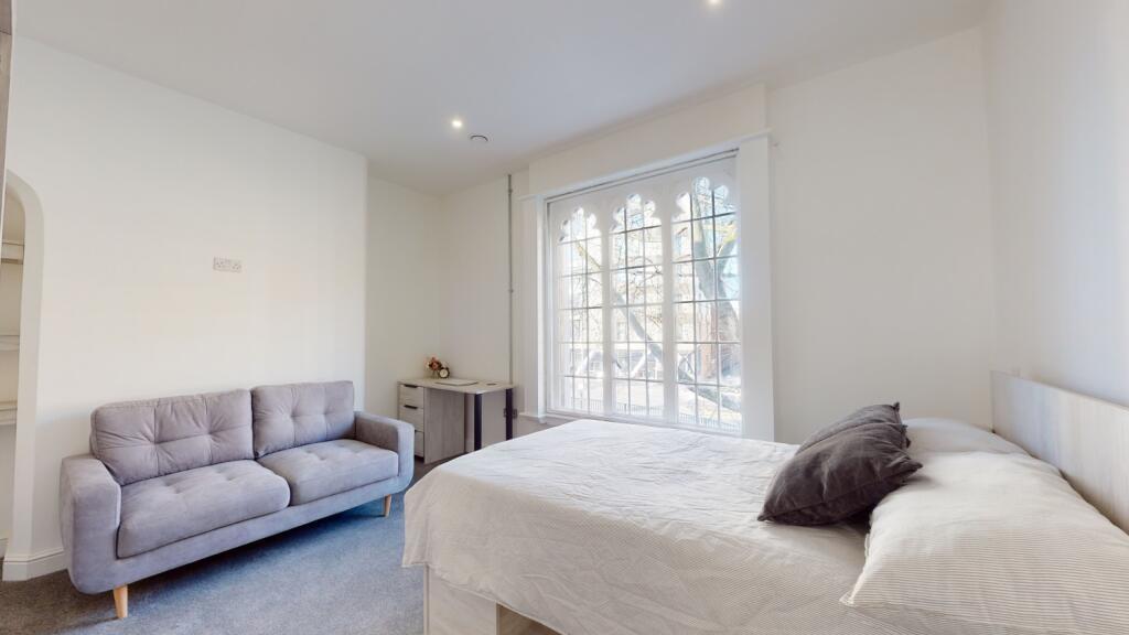 A bright and airy bedroom featuring a comfortab...