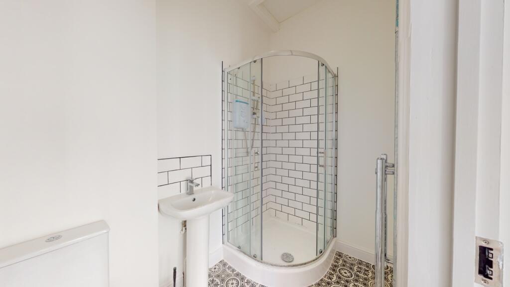 A clean and modern bathroom featuring a shower ...