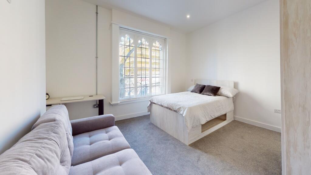 A bright and tidy bedroom featuring a double be...